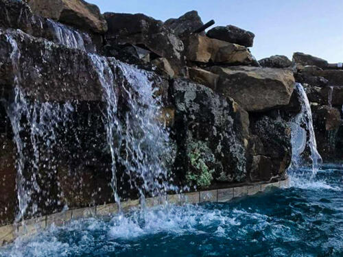 waterfall and swimming pool with boulders